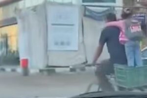 أب يصطحب ابنته إلى المدرسة على دراجة بسيطة في أجواء مليئة بالبهجة