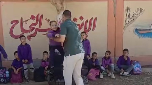 معلم يحمل تلميذًا من ذوي الهمم في قنا لتحقيق حلمه في مشهد إنساني مؤثر